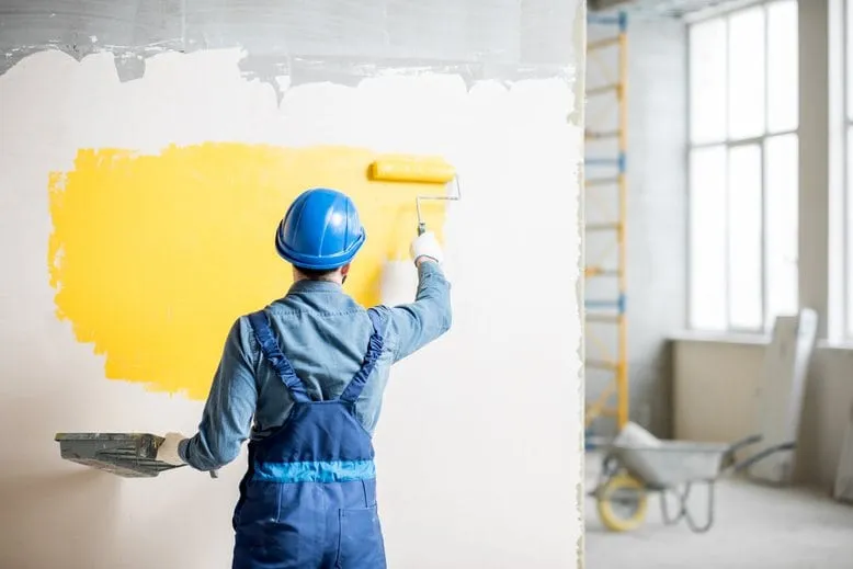 Craftsman painting a wall with a paint roller